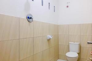 a bathroom with a toilet and a toilet paper dispenser at Lesehan Cahaya Tetebatu Inn Syariah at Desa Wisata in Tetebatu