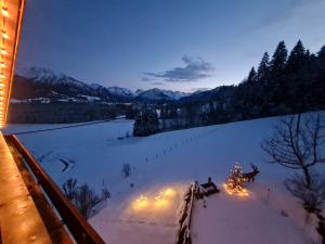 une chambre avec un arbre de Noël dans la neige dans l'établissement Landhaus Eggensberger, à Fischen im Allgäu