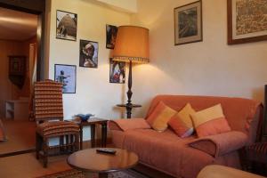 a living room with a couch and a table at Hôtel Restaurant Le Schlossberg in Zellenberg