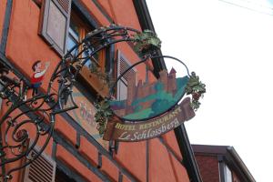 a sign hanging on the side of a building at Hôtel Restaurant Le Schlossberg in Zellenberg