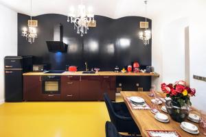 uma cozinha com uma mesa e um piso amarelo em Silvie Apartments - Blažejský em Olomouc