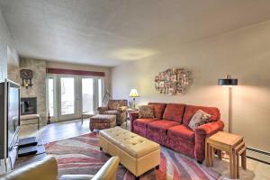 un soggiorno con divano rosso e TV di Grand Junction Golf Course Condo with Balconies a Grand Junction