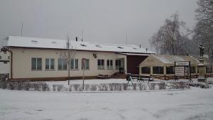 um edifício com neve no chão à sua frente em Na Rybníčku Bohutín em Bohutín