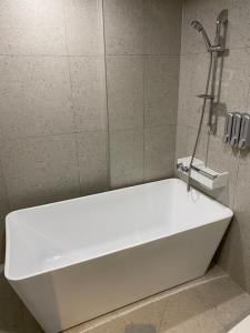 a white bath tub in a bathroom with a shower at Anseong City Hotel in Anseong