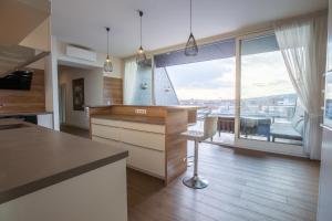 una cucina con bancone e una grande finestra di ZOYA LUXURY RESIDENCE a Budapest