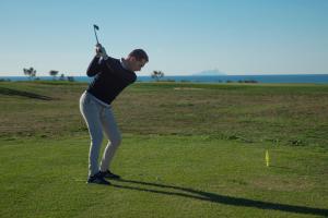 Um homem está a jogar golfe num campo de golfe. em Riva Toscana Golf Resort & SPA em Follonica