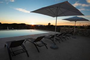 um grupo de cadeiras e guarda-sóis ao lado de uma piscina em Riva Toscana Golf Resort & SPA em Follonica