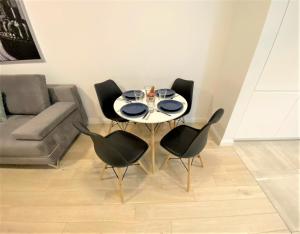 a dining room with a table and four chairs at EXCLUSIVE 2BR! Apartment in CENTER +NETFLIX +GYM in Warsaw