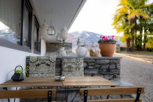 una mesa de madera y 2 sillas en el patio en Casa Alice Ascona, appartamento di vacanza., en Ascona