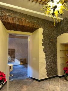 Habitación con pared de piedra y lámpara de araña. en Mesón de las Delicias, en Cuernavaca