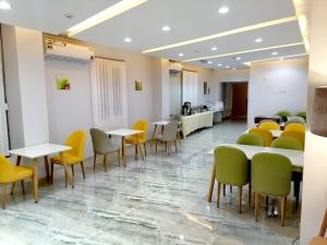 a waiting room with tables and yellow chairs at فندق المستقبل للشقق الفندقية ALMUSTAQBAL HOTEL Apartments in Ibrā