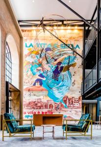 a mural in a room with two chairs and a table at Hotel Perte at Montecasino in Johannesburg