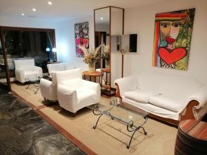 una sala de estar con muebles blancos y una pintura en la pared en Hotel Oasis, en Punta del Este