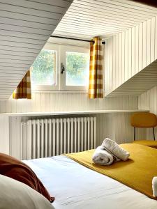 a bedroom with a bed with a yellow blanket and two windows at Relais Des Villards in Séez