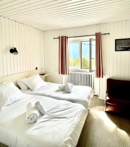 two white beds in a room with a window at Relais Des Villards in Séez