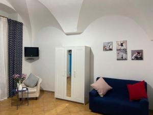 a living room with a blue couch and a tv at Maison Sosò in Naples