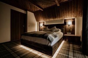 - une chambre avec un grand lit et des murs en bois dans l'établissement Gościniec Kuźnice, à Zakopane