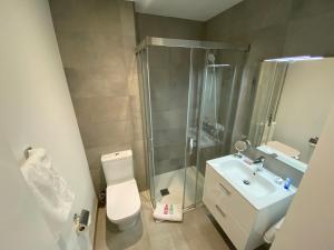 a bathroom with a shower and a toilet and a sink at Modern Studio Apartment at The Hub in Gibraltar