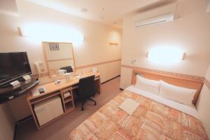 een hotelkamer met een bed, een bureau en een televisie bij Life Inn Katsuta Station West in Hitachinaka