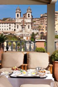 un tavolo con cibo sopra con vista su un edificio di Portrait Roma - Lungarno Collection a Roma