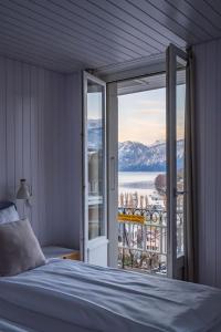 een slaapkamer met een bed en uitzicht op het water bij la belle vue Boutique Hotel & Café in Spiez