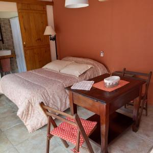 een slaapkamer met een bed en een tafel met bij Monoambiente en Colonia in Colonia del Sacramento