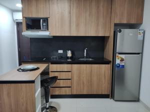 a small kitchen with a refrigerator and a microwave at Tuareg Suite Deluxe in Santa Cruz de la Sierra