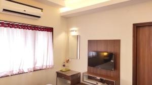 Habitación con TV de pantalla plana y ventana. en Hotel Rhythm Grand Suite, en Tiruchchirāppalli