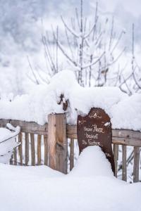 een bord bedekt met sneeuw op een hek bij Boutique Hotel Martha in Zell am See