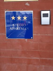 a blue sign on a brick wall with a sign for a studio apartment at Apartment Apex penthouse self check-in in Karlovac