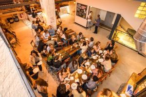 uma multidão de pessoas sentadas em mesas em um restaurante em Villa Saint Exupery Beach Hostel em Nice