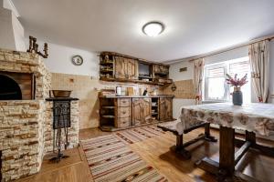 a living room with a table and a stone fireplace at Emerald House in Mykulychyn