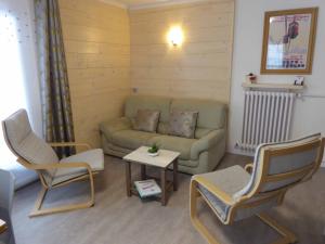 a living room with a couch and two chairs and a table at Chalet Monte-Pente in Megève