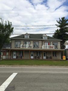 ein großes Haus mit Balkon auf der Straßenseite in der Unterkunft Orange Bistro in Baie-Saint-Paul