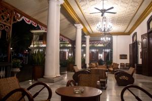 un restaurant avec des tables et des chaises et un lustre dans l'établissement Daroessalam Syariah Heritage Hotel, à Pasuruan