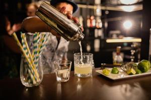 a person pouring a drink into a glass on a table at Rioca Stuttgart Posto 4 in Stuttgart