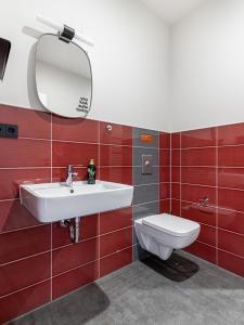 a bathroom with a white sink and a toilet at limehome Leipzig Oelßner's Hof in Leipzig