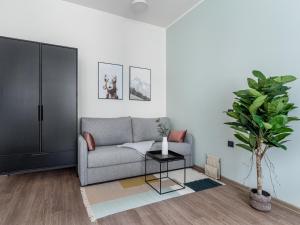 a living room with a couch and a potted plant at limehome Leipzig Oelßner's Hof in Leipzig