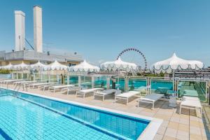 - une piscine avec des chaises et une grande roue dans l'établissement Hotel Colombo, à Lido di Jesolo