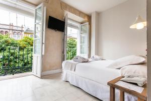 ein Schlafzimmer mit einem Bett und einem großen Fenster in der Unterkunft Hotel Boutique Elvira Plaza in Sevilla