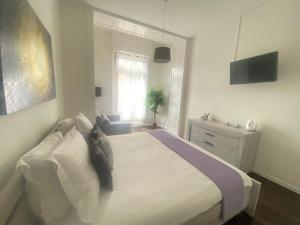 a white bedroom with a bed and a window at B&B Guest House Du Lac in Montreux