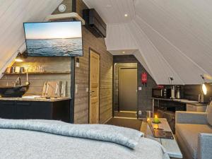 サッラにあるHoliday Home Samruam b aurora cabin by Interhomeの壁にテレビとベッドが備わる客室です。