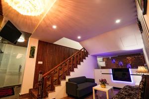 a living room with a staircase and a tv at Melanna Cherai Beach Resorts in Cherai Beach