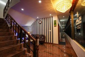 a staircase in a building with a chandelier at Melanna Cherai Beach Resorts in Cherai Beach