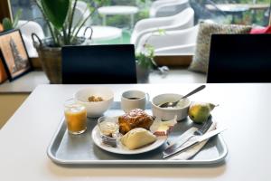 a tray with breakfast foods and drinks on a table at Auberge de Jeunesse HI Paris Yves Robert in Paris