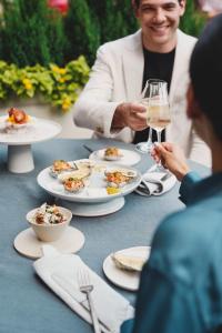 un grupo de personas sentadas en una mesa con platos de comida en Boston Harbor Hotel, en Boston