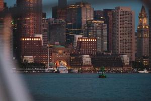 un perfil urbano por la noche con un barco en el agua en Boston Harbor Hotel, en Boston