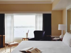 1 dormitorio con 1 cama y ventana con silla en Boston Harbor Hotel, en Boston