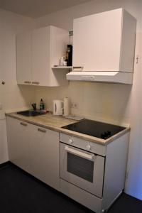 a kitchen with white cabinets and a stove top oven at Altstadtblick in Heidelberg