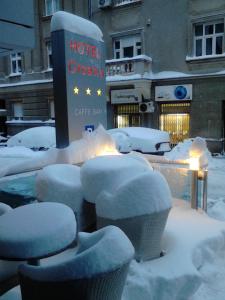 un groupe de chaises recouvertes de neige à côté d'un café-bar élégant de l'hôtel dans l'établissement Hotel Croatia, à Zagreb